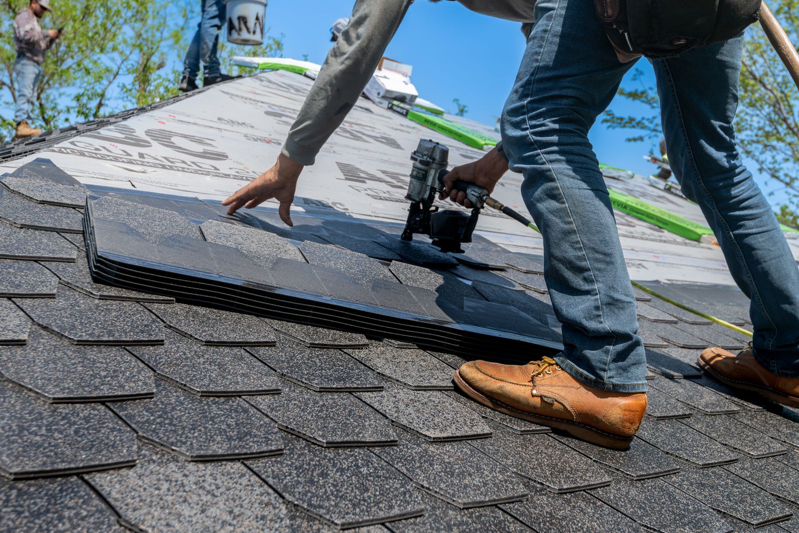 Crew member working on a rooftop with fall protection
